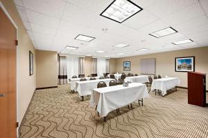 a conference room with white tables and chairs and a podium at Comfort Inn & Suites Decatur-Forsyth in Forsyth +50 photos