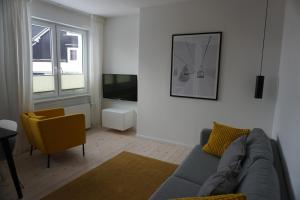 a living room with a blue couch and a yellow chair at Muggelbude im Harz in Braunlage
