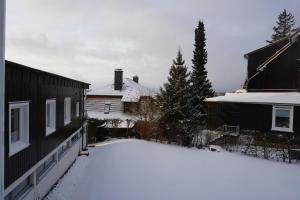 a yard covered in snow next to two buildings at Muggelbude im Harz in Braunlage