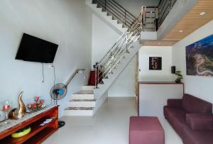 un soggiorno con scala e TV di RedDoorz at FJ Hotel Tubungan Iloilo a Tubungan
