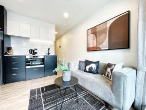 una sala de estar con un sofá y una mesa en Serene Cityscape Haven AC 1B VS Pool Gym & Sauna, en Auckland