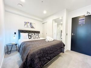 1 dormitorio con 1 cama grande y puerta azul en Serene Cityscape Haven AC 1B VS Pool Gym & Sauna, en Auckland 15 fotos más