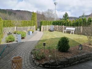 a garden with a table and a bench in a yard at Appartement Auszeit in Olsberg