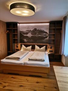 a bedroom with a bed with a large painting on the wall at Haus Tuklar in Brand