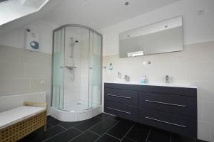 a bathroom with a glass shower and a sink at Ferienhaus-Ankerplatz in Norden +18 photos