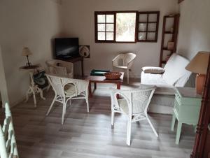 a living room with chairs and a table and a bed at grange aménagée in Mimizan