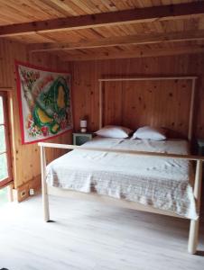 a bedroom with a bed in a wooden room at grange aménagée in Mimizan