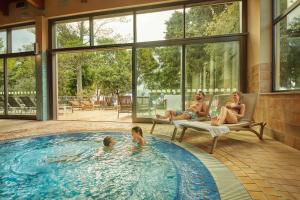 a family in a swimming pool in a house at Adria Apartments - Hotel & Resort Adria Ankaran in Ankaran