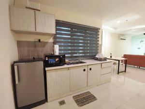 a kitchen with a refrigerator and a sink at D'Ocean Marina Laguna Resort by Manhattan Group in Lumut