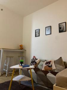 Lapu Lapu CityにあるCozy studio with pool 20 min from airportのソファとテーブルのあるリビングルーム