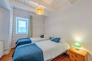 a bedroom with two beds and a table and a window at Ty Abéric maison en front de mer in Ploudalmézeau