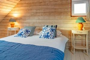 ein Schlafzimmer mit einem Bett mit blauen und weißen Kissen in der Unterkunft Ty Abéric maison en front de mer in Ploudalmézeau + 19 Fotos