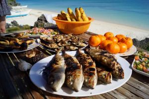 a table with plates of fish and other food at Michael's Native Homestay in Maricaban