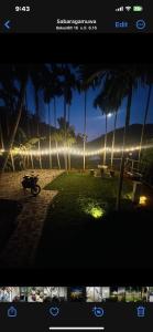 ein Bild eines Parks mit Palmen und einem Motorrad in der Unterkunft Puwak sewana cabana and resort පුවක් සෙවන in Warakapola