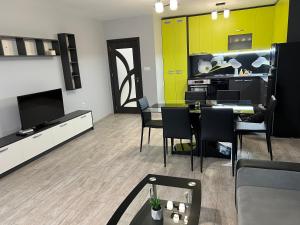 a living room with a tv and a table and chairs at Апартамент Трапезица in Veliko Tŭrnovo