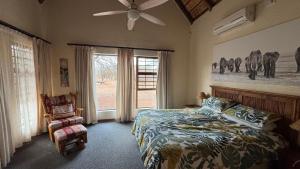 a bedroom with a bed and a fan and a window at Sondela Nature Reserve & Spa Makhato Lodges in Bela-Bela