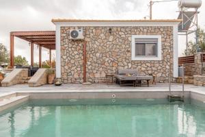 a house with a swimming pool in front of a building at Ampeli Villa in Kolymbia