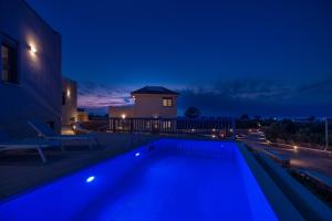 a swimming pool lit up at night at Elafonisos Aqua Villa III in Elafonisos