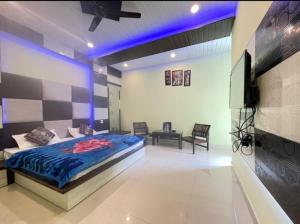 ダルハウジにあるOak wood Homestay Banikhetのベッドと薄型テレビのある寝室
