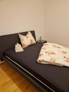 a bed with a black bed frame with a flowery pillow at Ruhiges und großzügiges Appartement in Sankt Valentin