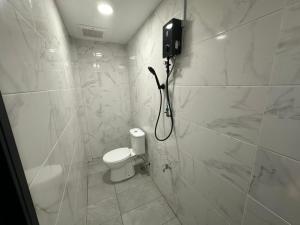 a white bathroom with a shower and a toilet at Home2828Stay - ROOMS ONLY in Sibu