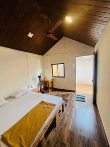 a large bed in a room with a wooden ceiling at The Coco Leaf Cafe in Gokarna +20 photos