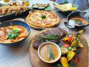 ラートクラバンにあるCanalis Suvarnabhumi Airport Hotelのテーブル(お皿、ピザ付)