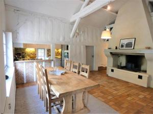 a kitchen and dining room with a wooden table and chairs at capbat in Commensacq