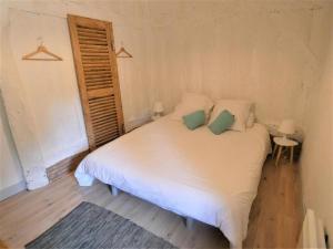 a bedroom with a white bed with two green pillows at capbat in Commensacq +25 photos