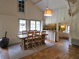 a dining room with a wooden table and chairs at capbat in Commensacq