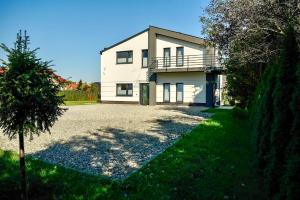 a white house with a driveway in front of it at Kwatery prywatne Lotnicza in Bielsko-Biala