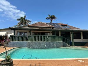 a house with a swimming pool in front of a house at Bleu Bird Guesthouse in Durban