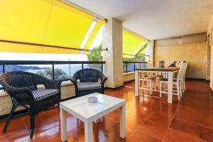 sala de estar con sillas y mesas y balcón en PLAYALARGA 2 - Planet Apartment, en Salou