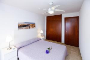 Un dormitorio con una cama y un ventilador de techo. en PLAYALARGA 2 - Planet Apartment, en Salou 24 fotos más