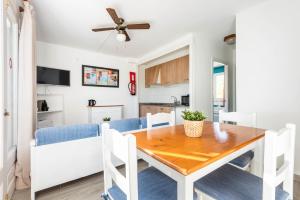 a dining room and kitchen with a table and chairs at Apartamentos Alta Galdana in Cala Galdana