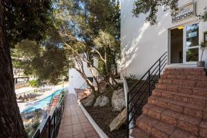 a staircase leading up to a house with a swimming pool at Apartamentos Alta Galdana in Cala Galdana