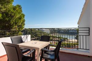 a table and chairs on a balcony with a view at Apartamentos Alta Galdana in Cala Galdana