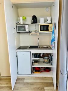 une petite cuisine avec des armoires blanches et un évier dans l'établissement Studio vue mer-port Arcachon, à Arcachon
