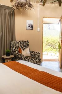 une chambre avec un lit, un canapé et une chaise dans l'établissement Wushwini Resort, à Durban