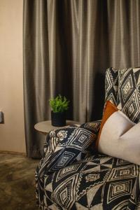 une personne assise sur un canapé avec une plante sur une table dans l'établissement Wushwini Resort, à Durban 15 autres photos