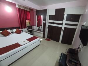 a bedroom with a bed and a tv in it at Hotel Viraat Inn in Gaya