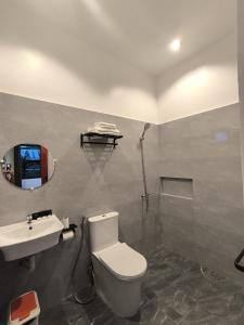 a bathroom with a toilet and a sink and a shower at Casa Marilag Guest House in Siquijor
