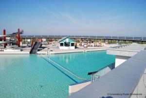 una grande piscina su una spiaggia con l'oceano sullo sfondo di Ferienwohnung Boje 9 mit Sauna a Dorum-Neufeld