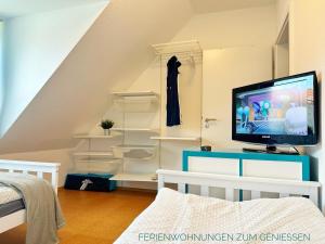una camera con TV e alcuni scaffali di Ferienwohnung Boje 9 mit Sauna a Dorum-Neufeld Altre 15 foto