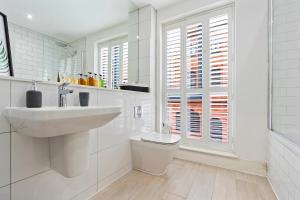 a white bathroom with a sink and a toilet at Luxurious 3 Bed Townhouse Bham Centre in Birmingham +28 photos