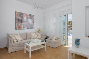 a living room with a couch and a table at Casa Bianca Villa in Kolimbia
