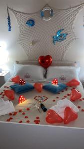 Un letto con i cuori sopra con delle rose rosse sopra. di Clemente House Catania Centro MERAVIGLIOSA camera matrimoniale a Catania