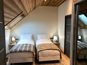 two beds in a small room with a mirror at Villa à 200mètres du lac avec terrasse privée in Sévrier