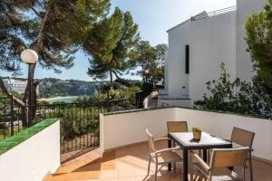 a patio with a table and chairs on a balcony at Apartamentos Alta Galdana in Cala Galdana