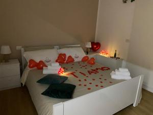 una camera da letto con un letto con cuori rossi e palloncini di Elegante matrimoniale clemente house catania centro a Catania